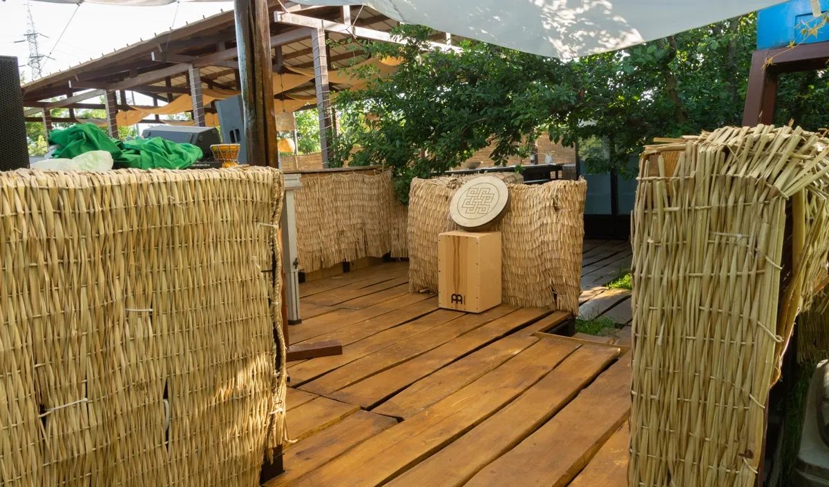 Decking de lemn cu paravane de stuf și vegetație